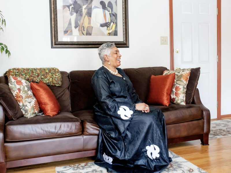 Rev. Dr. C. Diane Mosby sitting on couch in black dress