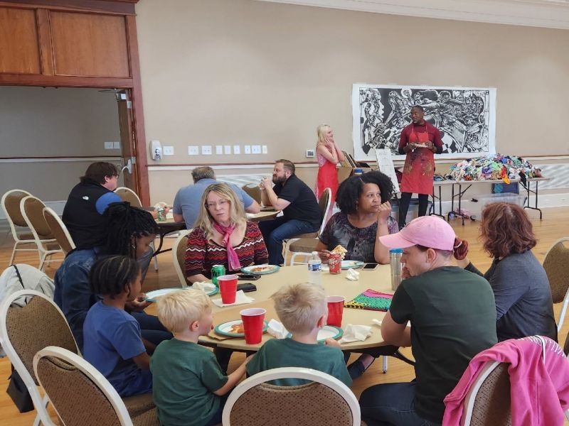 people sitting around a table at a quilt workshop