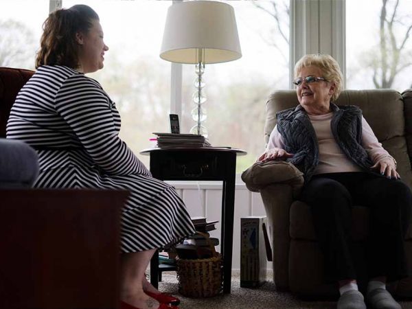 Rebekah Ralph sitting with congregant; women talking