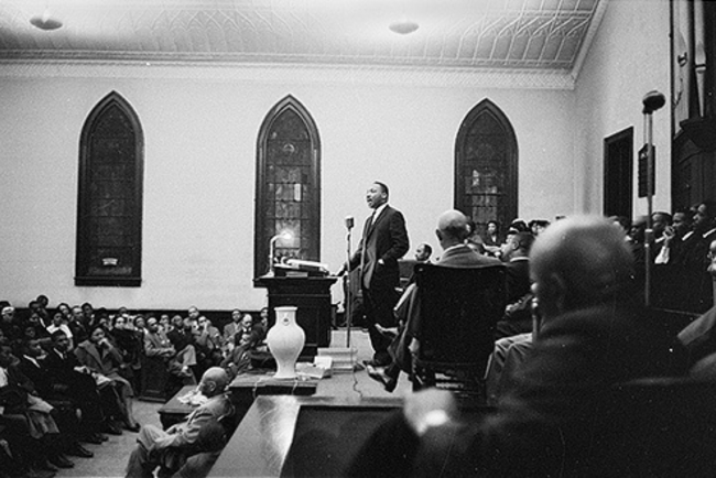 MLK speaking to crowd in black and white photo