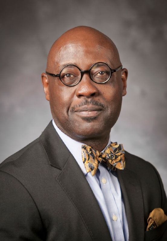 Rev. Dr. Willie Jennings Headshot in gray suit and yellow bow tie