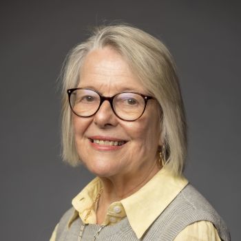 Janet Martin Soskice headshot in red shirt and red paisley scarf