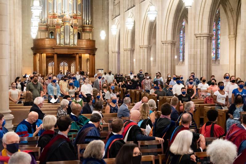 New students stand during Opening Convocation in Duke Chapel.