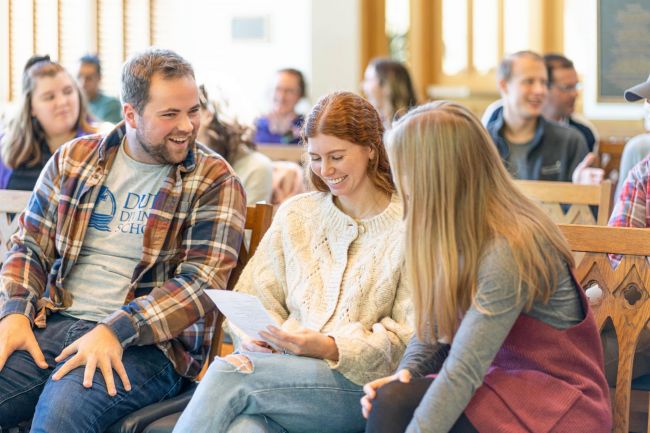 Students laugh together while sitting in Goodson Chapel