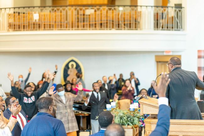 Divinity School community members raise hands in worship