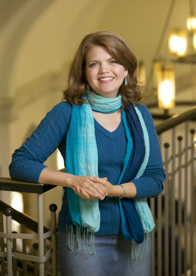 Meghan Benson headshot in dark blue sweater and multi-shaded bluescarf