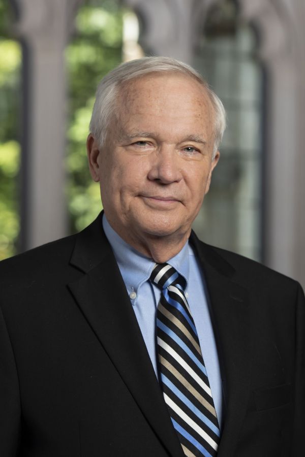 Will Willimon poses in a suit in Goodson Chapel