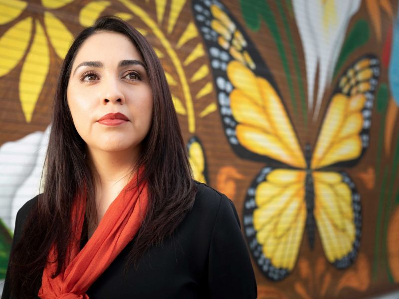 Alma Tinoco Ruiz in front of butterfly mural
