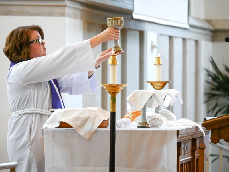 Meghan Benson holding up communion cup in Goodson Chapel