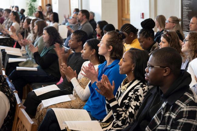 Attendees clap during worship service