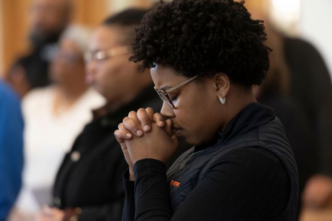 Student praying at the 15th Anniversary of the Prison Studies Program