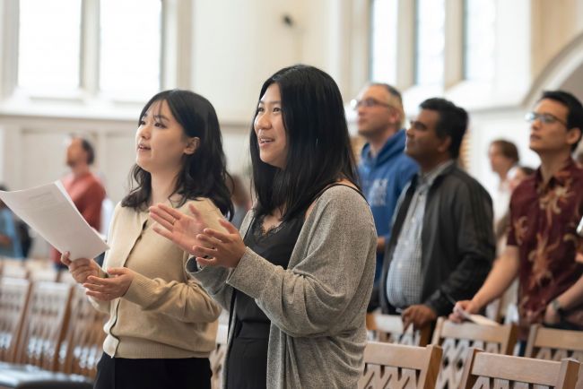 Students clap during worship service in Goodson Chapel