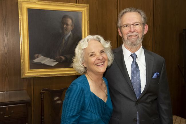 Richard and Judy Hays stand in front of his portrait installed in the AMCR room of Duke Divinity school