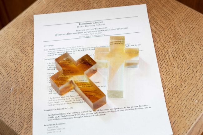 Glass crosses laid over an order of service from 2021
