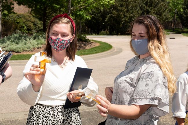Students receive glass crosses outside during 2021