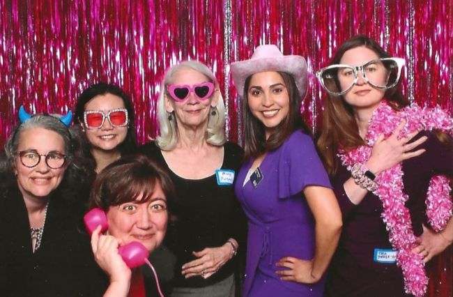 Faculty advisors for the Women's Center pose in a photobooth