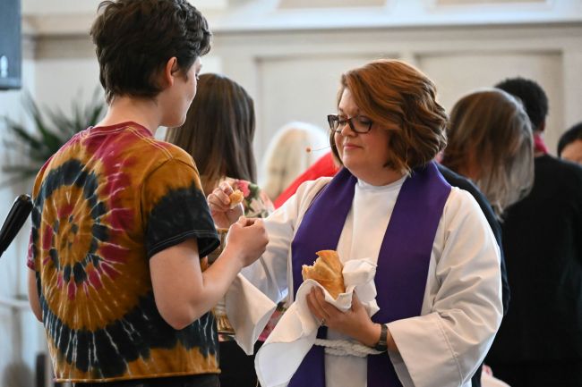 Meghan Benson serves communion in Goodson Chapel during the Women's Center 50th Anniversary