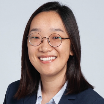 Deborah Park wearing wire rimmed glasses, a white shirt, and navy blazer