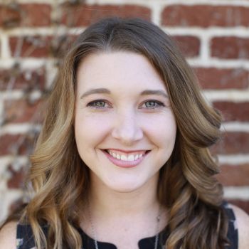 Woman smiling against brick wall