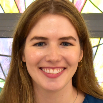 Liz McQuaid headshot near stained glass
