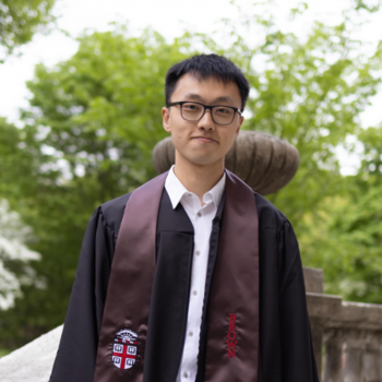 Tony Pan wearing glasses and graduation robe from Brown University