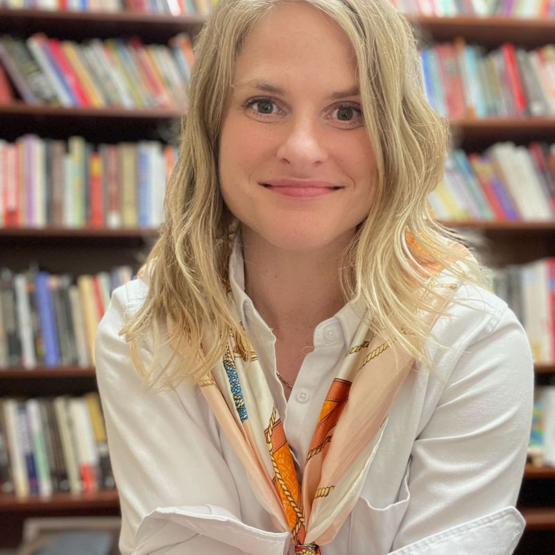 headshot of woman in front of books