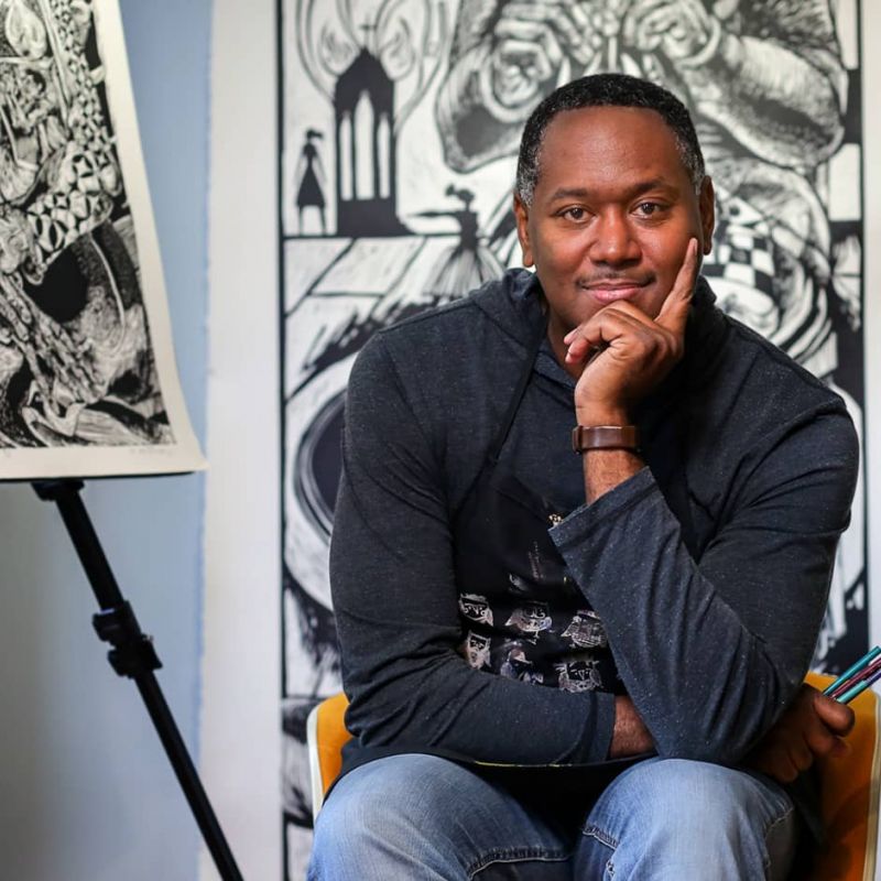 headshot of artist Steve Prince with linocuts in background
