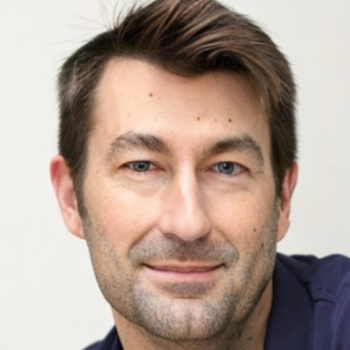 Ryan Bayley headshot in dark blue collared shirt