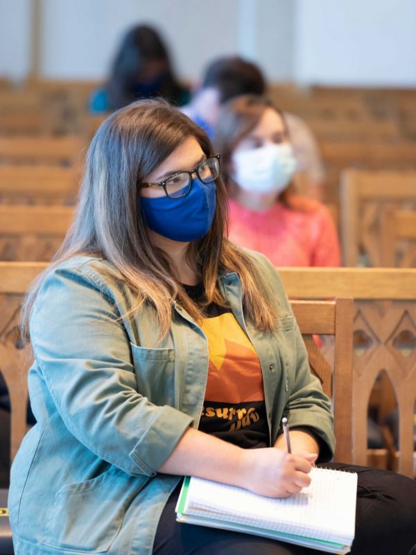Mackenzie Fair takes notes in her Church History class held in Goodson Chapel
